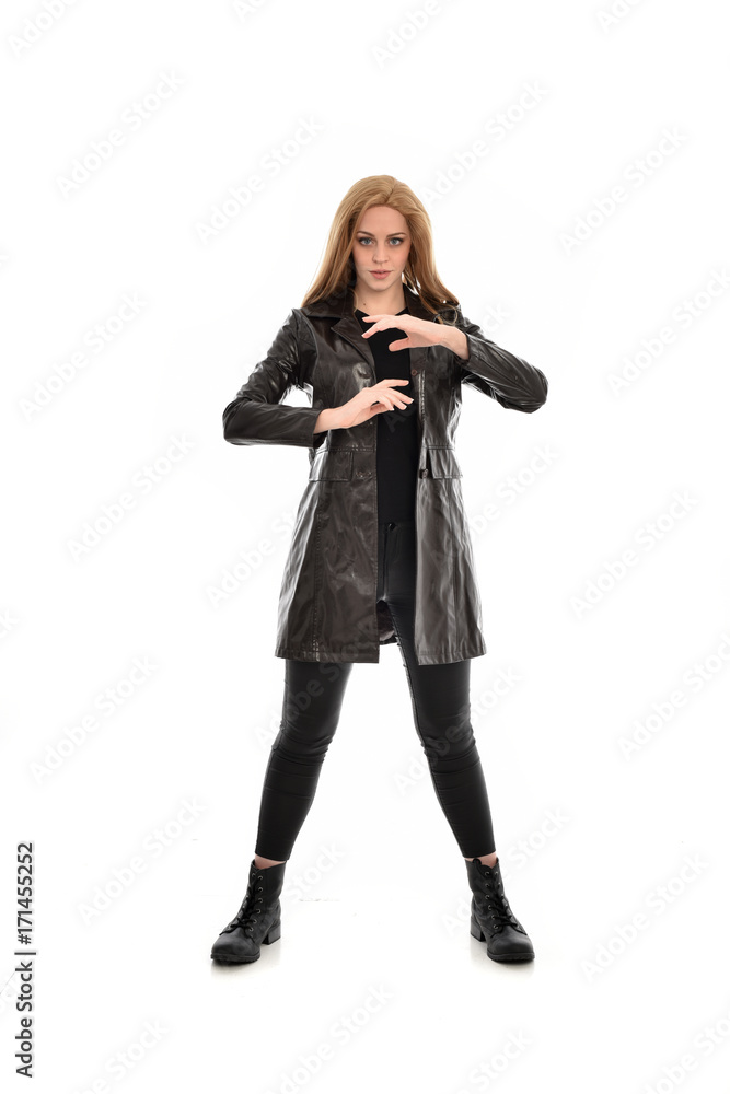 full length portrait of girl wearing black clothes with long leather jacket. standing pose on white background. full length portrait of girl wearing black clothes with long leather jacket. standing pose on white background.