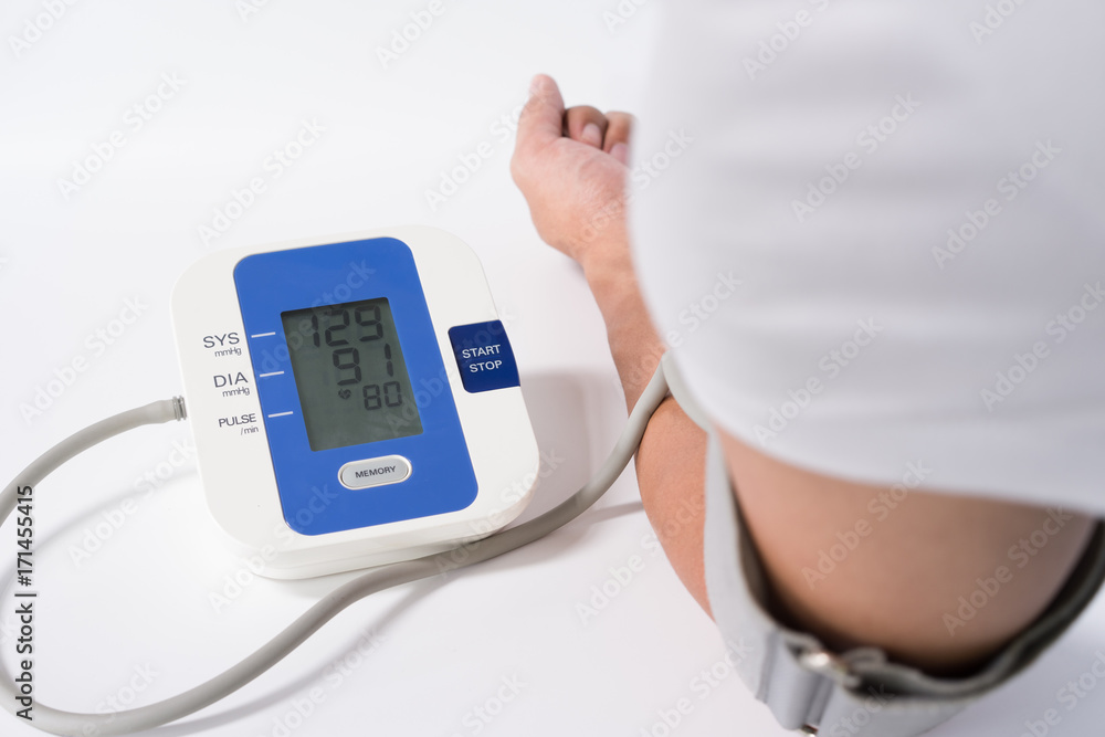 Digital Blood Pressure Monitor with the arm of a man on white background Digital Blood Pressure Monitor with the arm of a man on white background