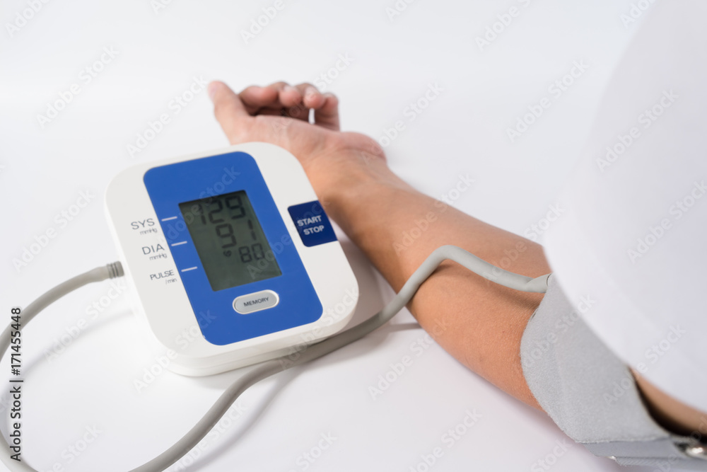 Digital Blood Pressure Monitor with the arm of a man on white background Digital Blood Pressure Monitor with the arm of a man on white background