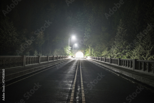 View of empty road passing through tunnel during night photo