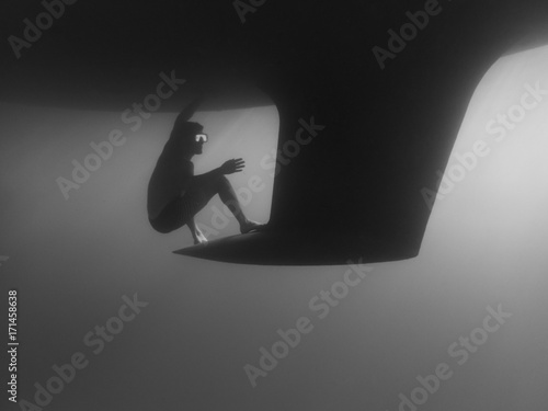 Side view of man swimming by keel undersea