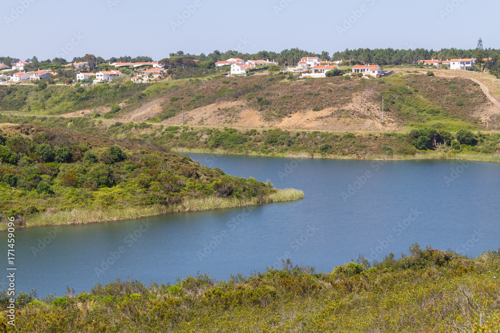 Houses, lake and trail in mountain in Arrifana