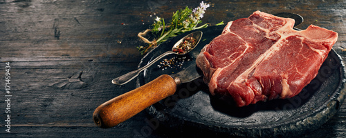 Fotografie Raw porterhouse steak and fresh herbs