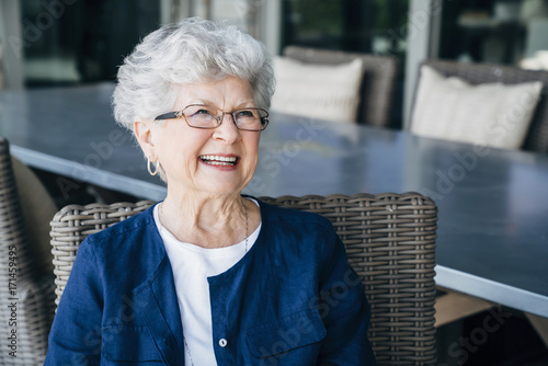 Smiling senior woman relaxing on porch