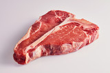 Thick tender raw t-bone steak on white