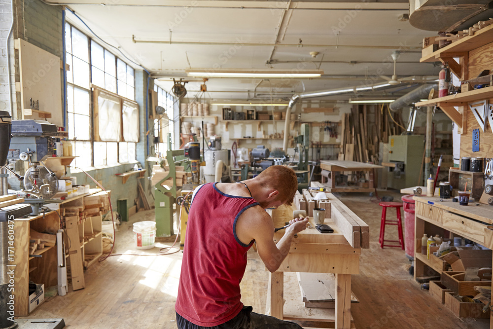 Rear view of carpenter working in workshop Rear view of carpenter working in workshop