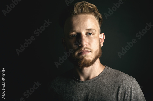 portrait of young man above black background