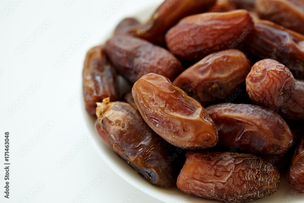 Bowl of dried dates isolated on white backgroun Bowl of dried dates isolated on white backgroun