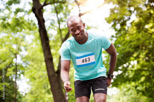 Young fit afro-american man running in park.