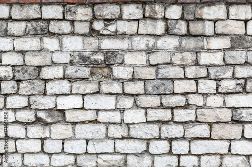 The old stone walls. The brick wall of the house. Grey textured background. Abstraction.