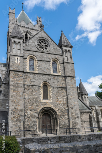 Dublin, Ireland - August 7, 2017: Gray stone bell tower of Christ Church Cathedral against blue sky with white clouds.