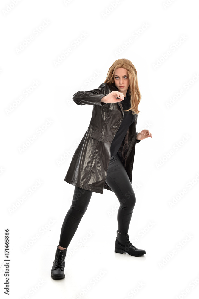 full length portrait of girl wearing black clothes with long leather jacket. standing pose on white background. full length portrait of girl wearing black clothes with long leather jacket. standing pose on white background.