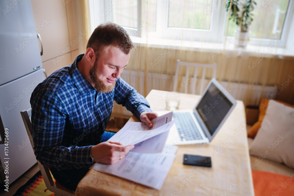 Handsome man doing some paperwork at home Handsome man doing some paperwork at home