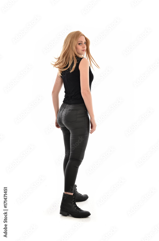 full length portrait of girl wearing black clothes and long leather jacket. standing pose in white background. full length portrait of girl wearing black clothes and long leather jacket. standing pose in white background.