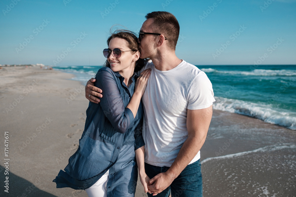 Beautiful young couple on the sandy beach of the sea