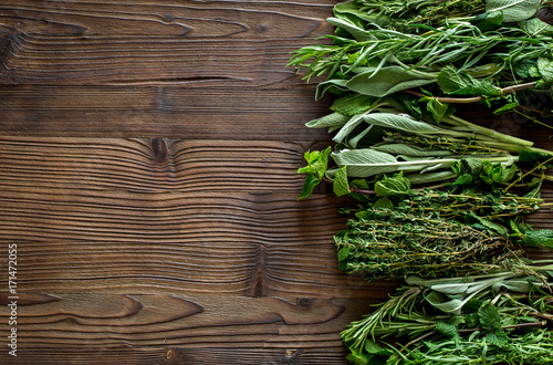 drying fresh herbs and greenery for spice food on wooden kitchen desk background top view space for text