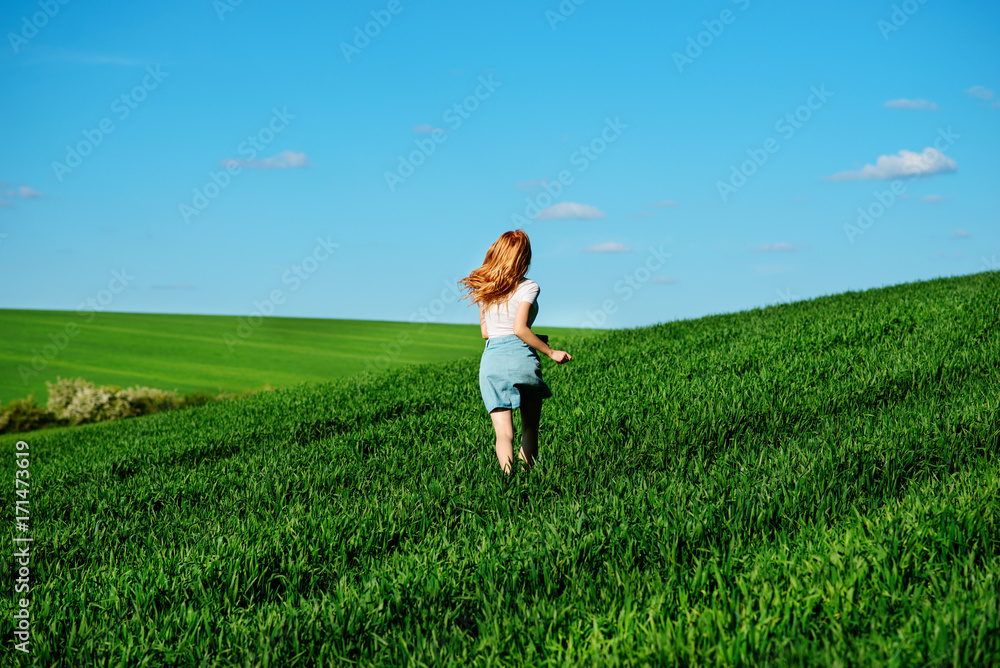 Young beautiful woman running on a green field Young beautiful woman running on a green field
