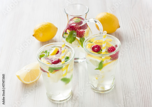 Fresh lemon and raspberry water drink / Fresh lemon and raspberry cold water drink lemonade with mint in two glass