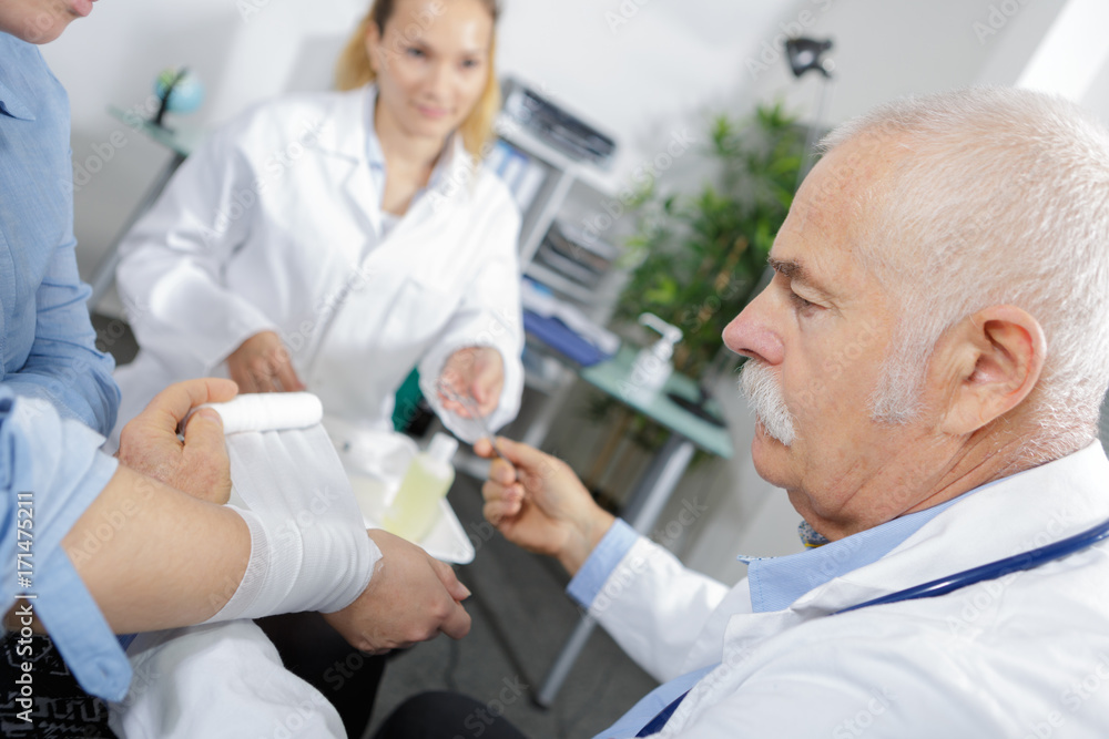 Obraz premium female and male doctor bandaging the arm of a patient