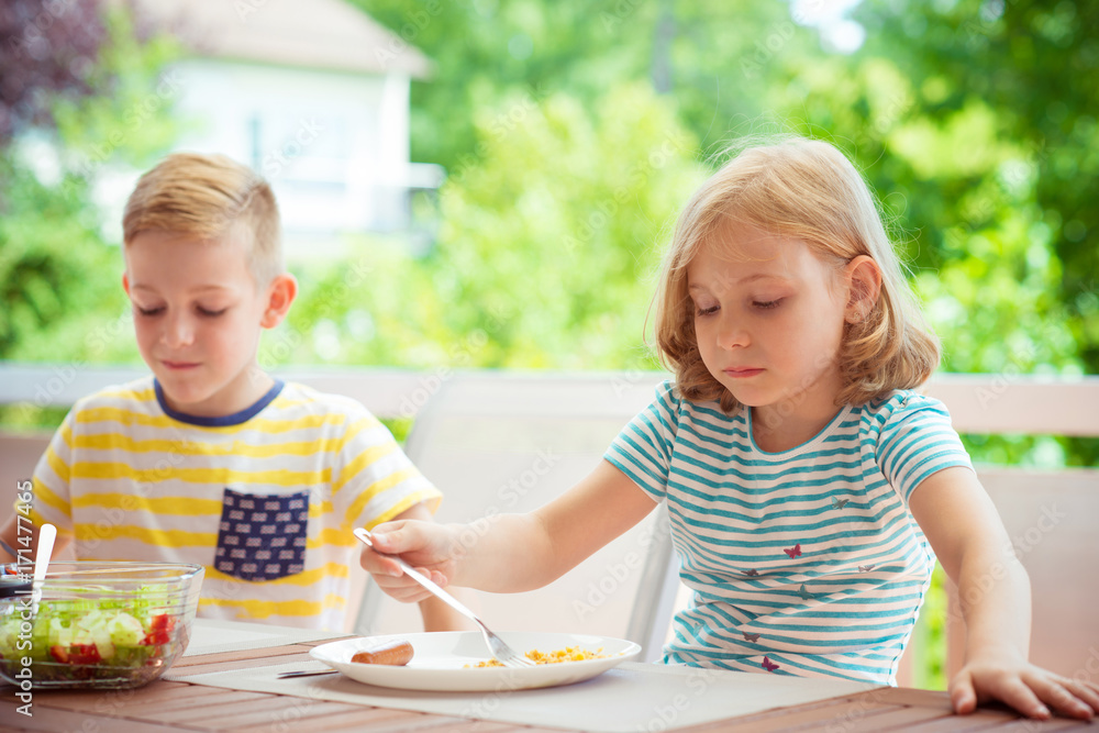 Two happy little children eating healthy breakfast at home Two happy little children eating healthy breakfast at home