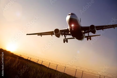 Fotografie starting airplane in front of a the evening sun