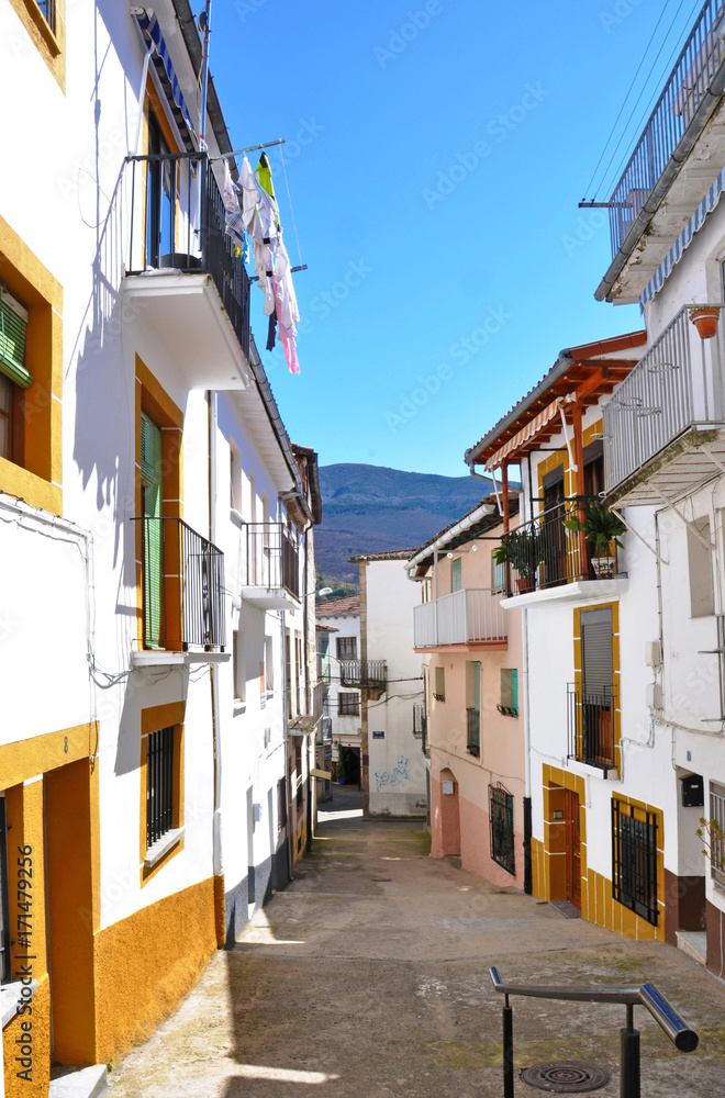 Narrow sunlit street with a mountain view