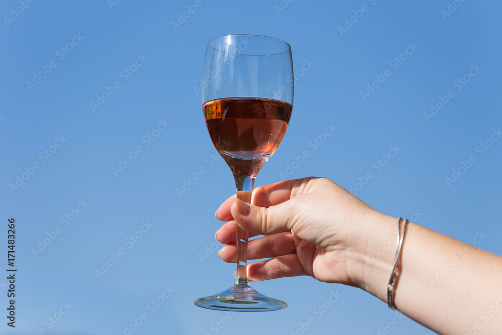 A glass of wine is a toast against the blue sky