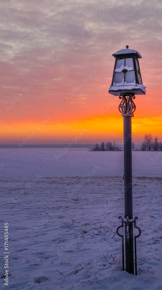 The red color of the sunset. Winter red sunset. Lantern at sunset.