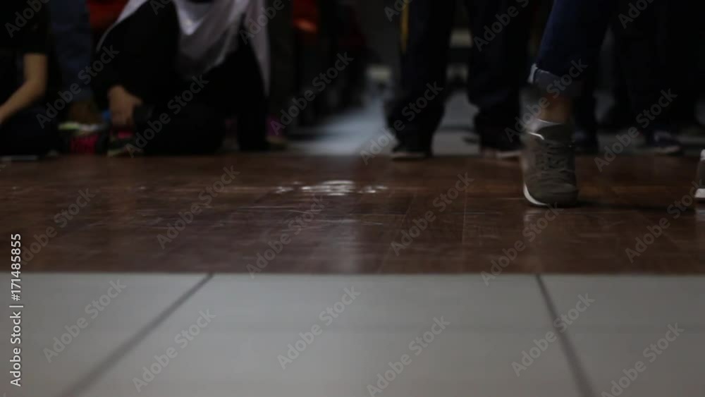 The legs of the dancer in sneakers move to the rhythm of dance in the style of hip-hop. The legs of the dancer in sneakers move to the rhythm of dance in the style of hip-hop.