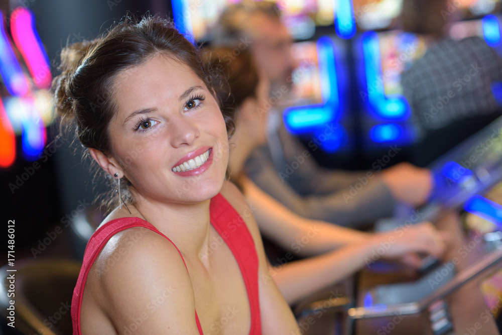 smiling young woman ready to play at slot machine
