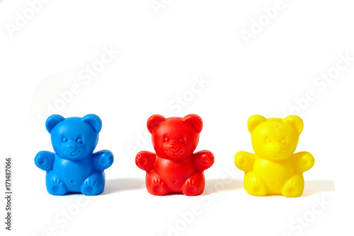 Blue, red and yellow plastic toy bears isolated on white background