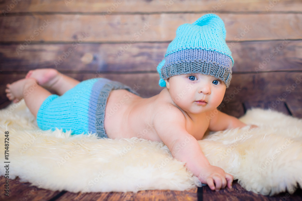 likable and pretty newborn baby boy with big blue eyes in a