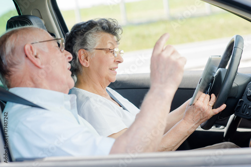 a senior couple driving a car