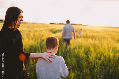 Mother and son walking away through the field photo