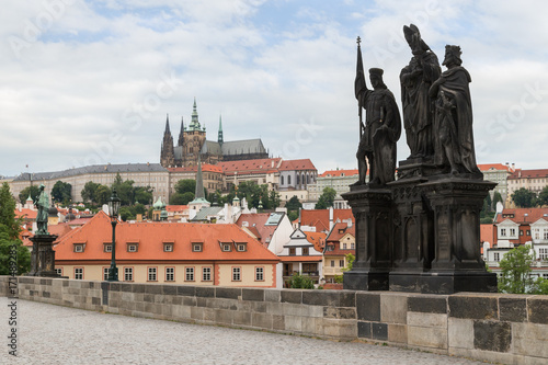 View of Prague Castle and other buildings at the Mala Strana district and statue of Saints Norbert of Xanten, Wenceslas and Sigismund on the north side of the Charles Bridge (Karluv most) in Prague.
