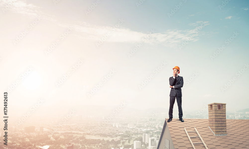 Engineer man standing on roof and looking away. Mixed media Engineer man standing on roof and looking away. Mixed media
