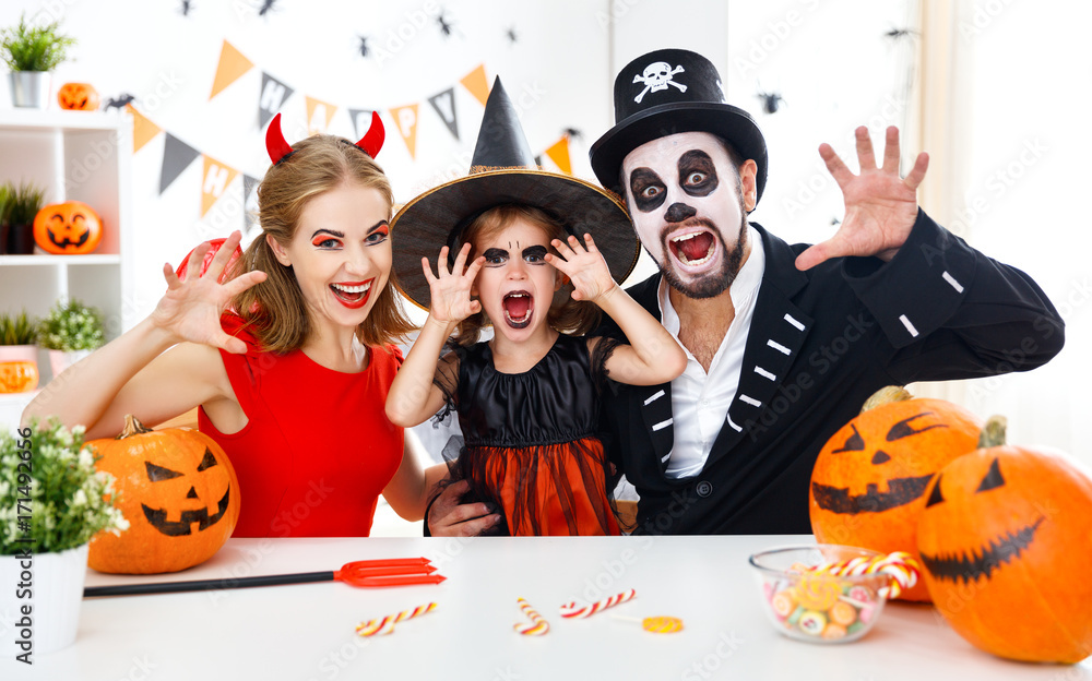 happy family in costumes getting ready for halloween at home. happy family in costumes getting ready for halloween at home.