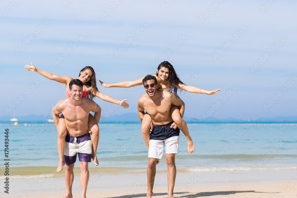 Two Couple On Beach Summer Vacation, Young People Happy Smiling, Man Carry Woman Sea Ocean Holiday Travel Two Couple On Beach Summer Vacation, Young People Happy Smiling, Man Carry Woman Sea Ocean Holiday Travel