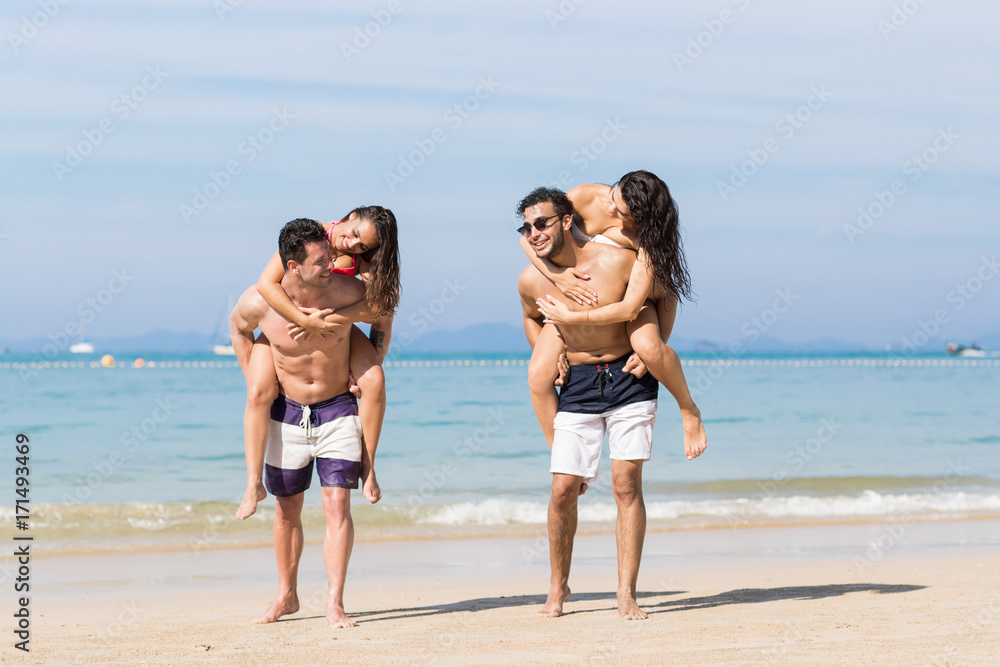 Two Couple On Beach Summer Vacation, Young People Happy Smiling, Man Carry Woman Sea Ocean Holiday Travel Two Couple On Beach Summer Vacation, Young People Happy Smiling, Man Carry Woman Sea Ocean Holiday Travel