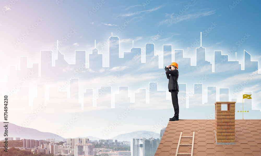 Engineer man standing on roof and looking in binoculars. Mixed media Engineer man standing on roof and looking in binoculars. Mixed media