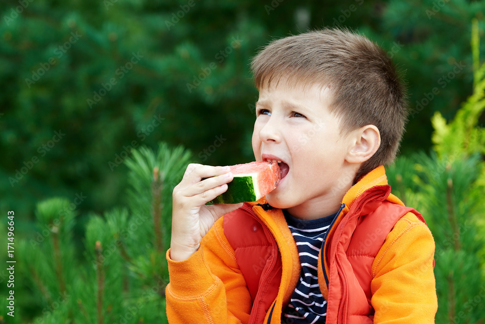 Cute Caucasian boy eating water melon outdoor. Cute Caucasian boy eating water melon outdoor.