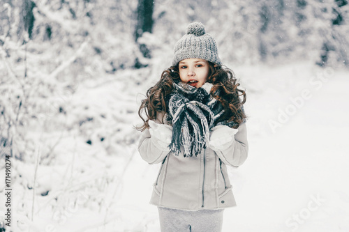 Portrait of cute little girl in winter forest.