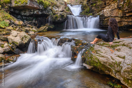 Young girl looks at Puente Ra waterfall  La Rioja  Spain   