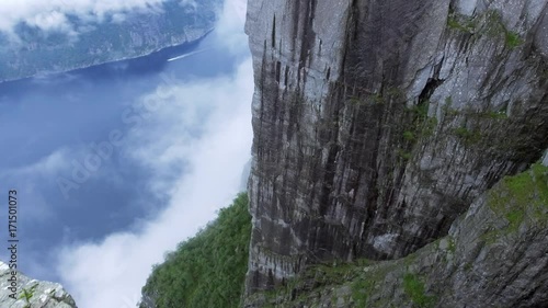 Aerial shot flight over the edge of cliff. Norway, Europe. Preikestolen Landscape, Prekestolen, Preacher's Pulpit, Pulpit Rock. Magnificent scenery, mountains, steep cliffs in fog. Tourist attraction