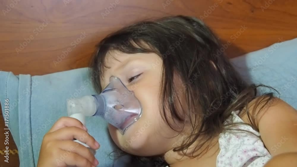 The child has asthma. A little girl with a nebulizer makes inhalation. The child has asthma. A little girl with a nebulizer makes inhalation.
