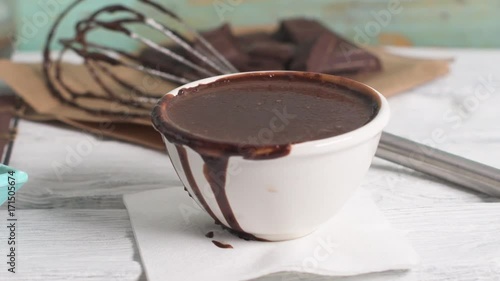 Traditional churros with hot chocolate dipping sauce on wooden counter top.