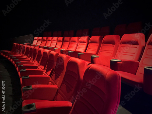 New unused movie theater seats. Red seat rows in auditorium.