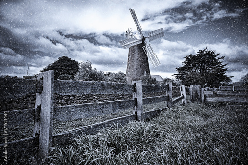 Windmill in the countryside covered in artificial rain and snow. photo