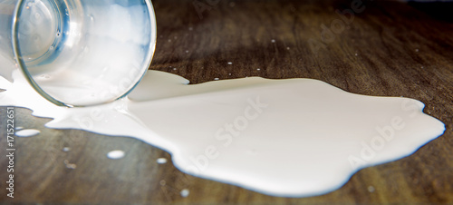 Cuadro en lienzo ein Glas mit verschütteter Milch liegt auf einem Tisch