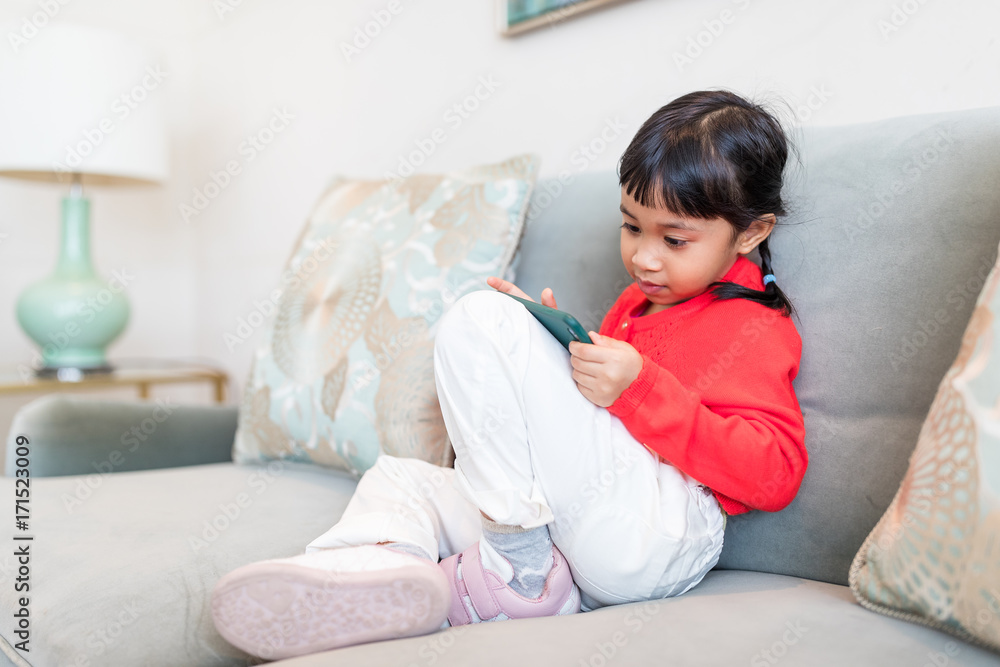 Little girl using cellphone at home Little girl using cellphone at home